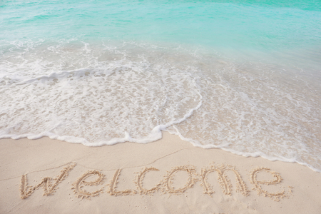 Word WELCOME on beach sand. Summer vacation conceptの写真素材