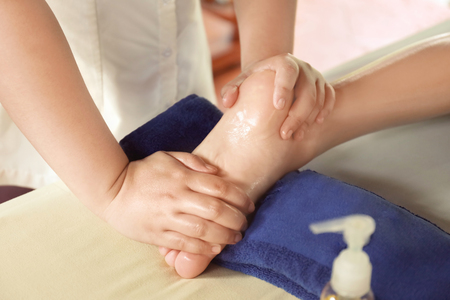 Beautiful young woman receiving massage in spa salonの写真素材
