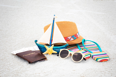 Passports and tickets with beach accessories on sand. Summer vacation concept