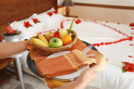 Young woman with tasty fruits in hotel room prepared for romantic dateの写真素材