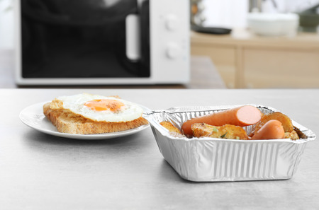 Nutritious lunch from fried potato, sausages and egg with toast on tableの写真素材