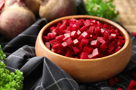 Wooden bowl with sliced beetroot on table, closeupの写真素材