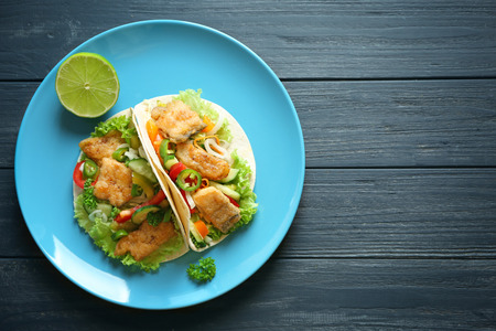 Plate with delicious fish tacos on wooden tableの写真素材