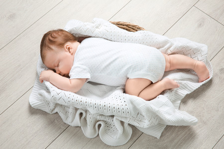 Cute newborn baby sleeping in basket at homeの写真素材
