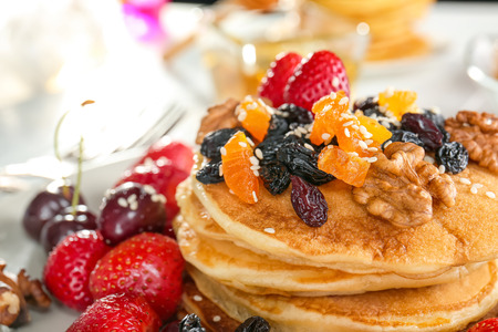 Plate with tasty pancakes, walnuts, dried fruits and berries, closeupの写真素材