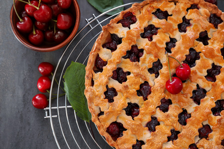 Tasty cherry pie and fresh berries on tableの写真素材