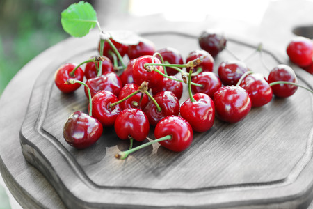Tasty ripe cherries on wooden board outdoorsの写真素材