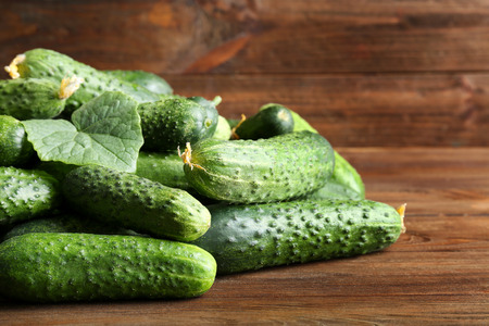 Many green fresh cucumbers on wooden tableの写真素材