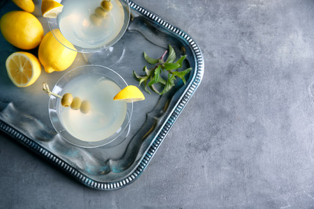 Glasses of lemon drop martini with olives on metal trayの写真素材