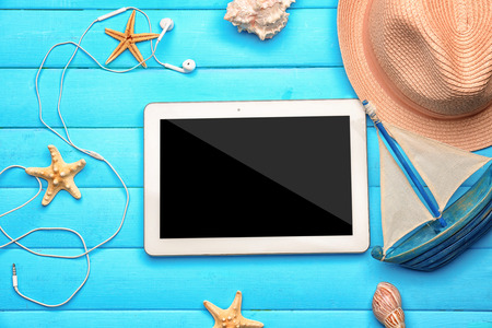 Composition with tablet and hat on wooden background. Vacation conceptの写真素材