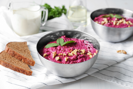 Bowls of fresh beet hummus on tableの写真素材