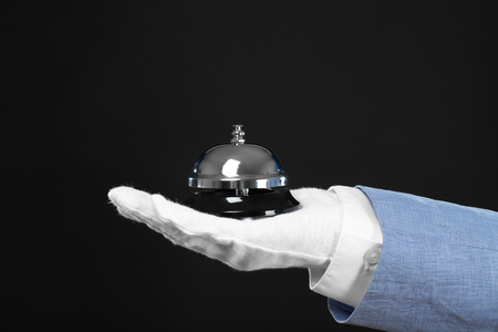 Man holding bell on black backgroundの写真素材