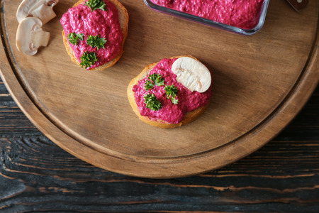 Bread with delicious beet hummus on wooden boardの写真素材