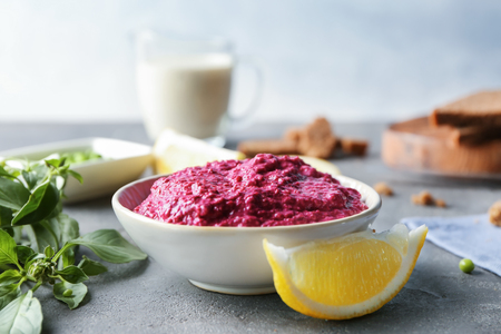 Bowl of fresh beet hummus on tableの写真素材