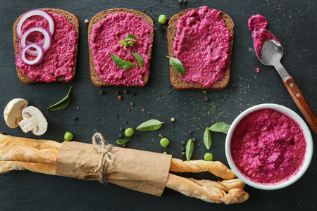 Bowl with delicious creamy beet hummus and bread on dark backgroundの写真素材