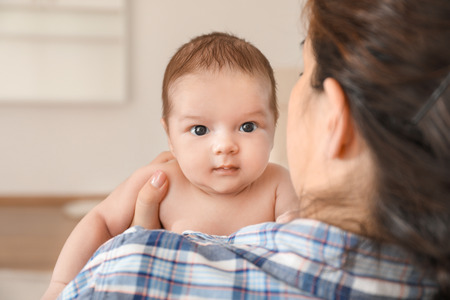 Young mother with cute baby at homeの写真素材