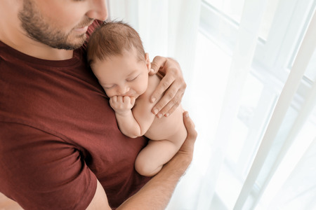 Father with cute little baby at home
