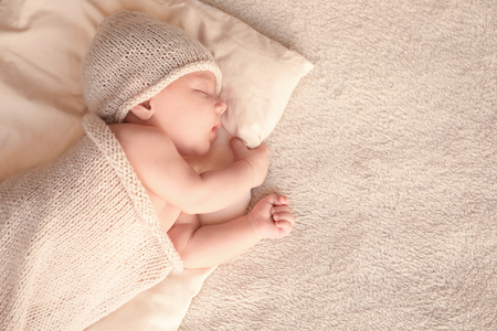 Cute little baby sleeping on bed at homeの写真素材