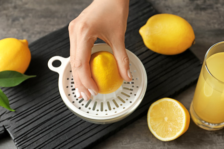 Woman squeezing lemon juice in kitchen