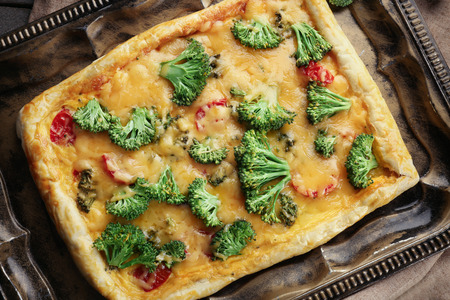 Traditional quiche with broccoli and cheese on trayの写真素材