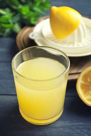 Glass of fresh lemon juice on wooden tableの写真素材