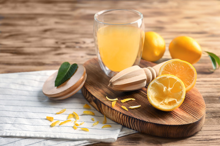 Composition with lemon juice and squeezer on wooden backgroundの写真素材