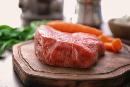 Piece of raw meat on wooden boardの写真素材