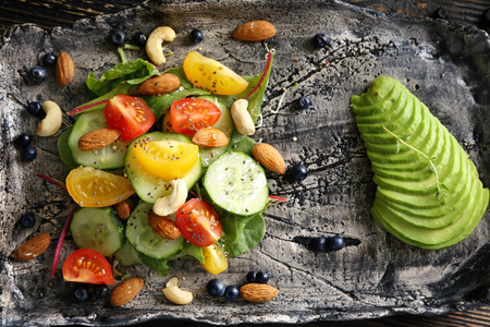 Superfood salad with tomato, cucumber and zucchini on handmade plate, top viewの写真素材