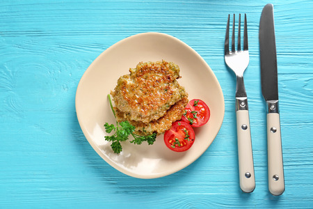 Delicious broccoli pancakes with cherry tomato and fresh parsley on blue wooden backgroundの写真素材