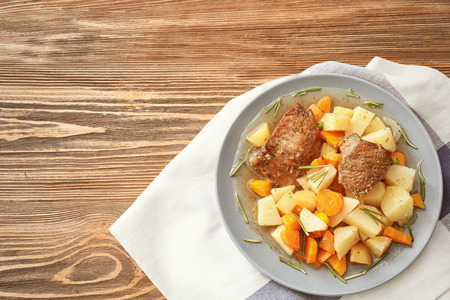 Plate with tasty meat and potatoes on tableの写真素材