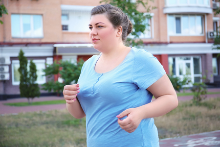 Overweight woman running, outdoorsの写真素材