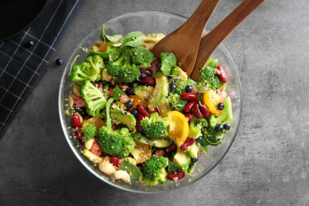 Superfood salad with broccoli and beans in glass bowl on kitchen tableの写真素材
