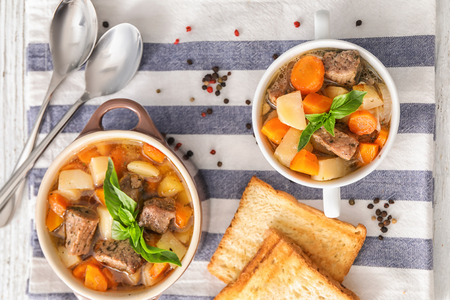 Casseroles with tasty meat and potatoes on tableの写真素材