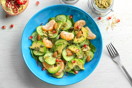 Superfood salad with avocado, tangerine and almond on light background, top viewの写真素材