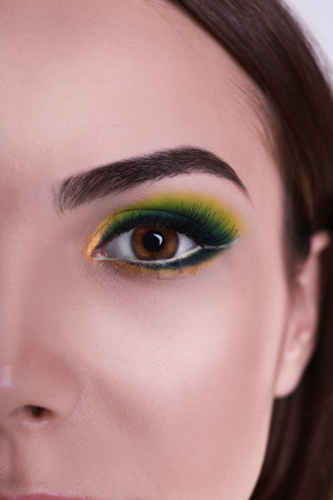Young beautiful woman with fancy green makeup, closeupの写真素材