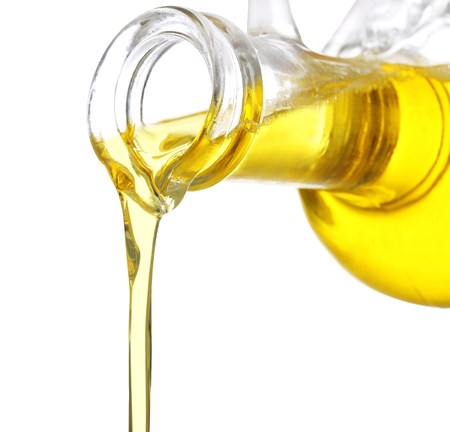 Pouring cooking oil from pitcher on white background, closeupの写真素材