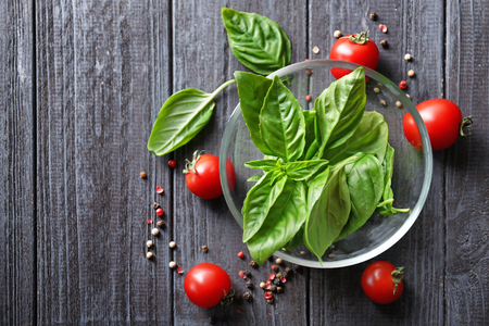 Green fresh organic basil and cherry tomatoes on wooden backgroundの写真素材