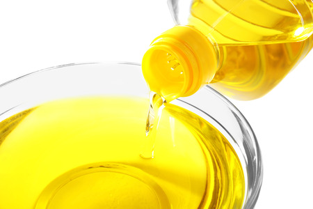Pouring cooking oil into glass bowl on white background, closeupの写真素材