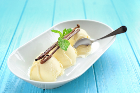 Plate with delicious vanilla ice-cream balls on tableの写真素材