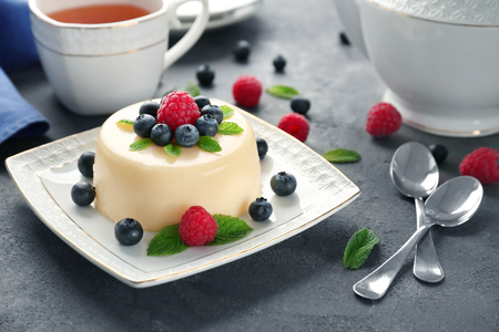 Delicious vanilla pudding with berries on tableの写真素材