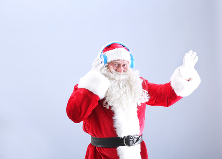 Santa Claus listening to music on color backgroundの写真素材