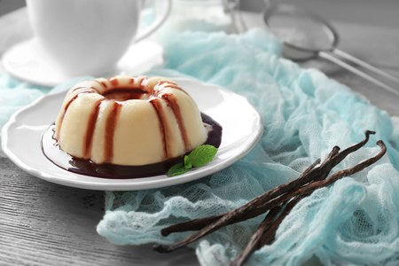 Delicious vanilla pudding with chocolate syrup on plateの写真素材
