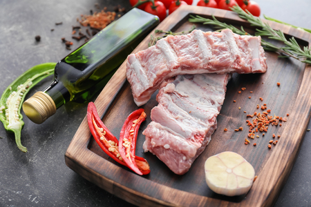 Wooden board with fresh raw meat on tableの写真素材