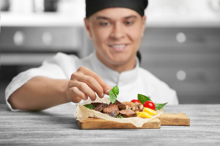 Chef decorating tasty juicy meat on tableの写真素材