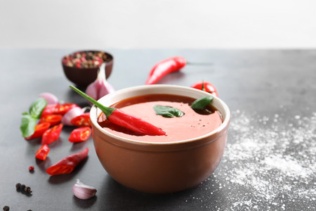 Composition with chili sauce in bowl on tableの写真素材