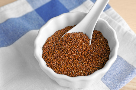 Bowl and spoon with quinoa seeds on tableの写真素材