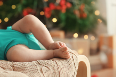 Cute little baby sleeping against blurred Christmas lights backgroundの写真素材