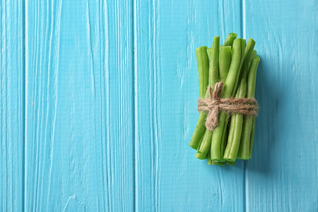 Bunch of fresh green beans on wooden background