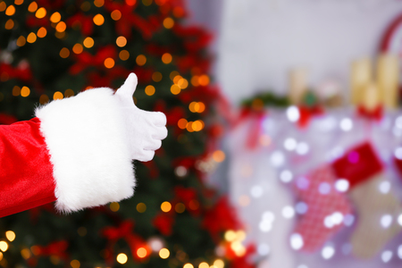 Santa Claus hand against blurred Christmas lightsの写真素材