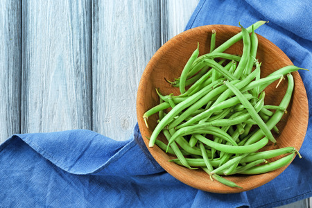 Bowl with fresh green beans on wooden backgroundの写真素材